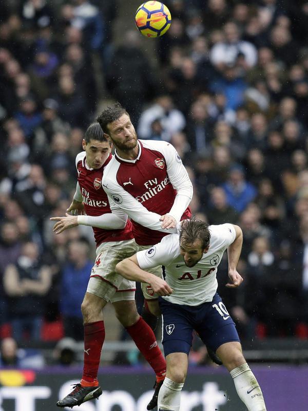 Tottenham Hotspur, Arsenal, Premier League Harry Kane (kanan) saat berebut bola dengan dua pemain Arsenal pada lanjutan Premier League di Wembley stadium, London, (10/2/2018). Tottenham menang tipis 1-0 atas Arsenal. (AP/Tim Ireland)